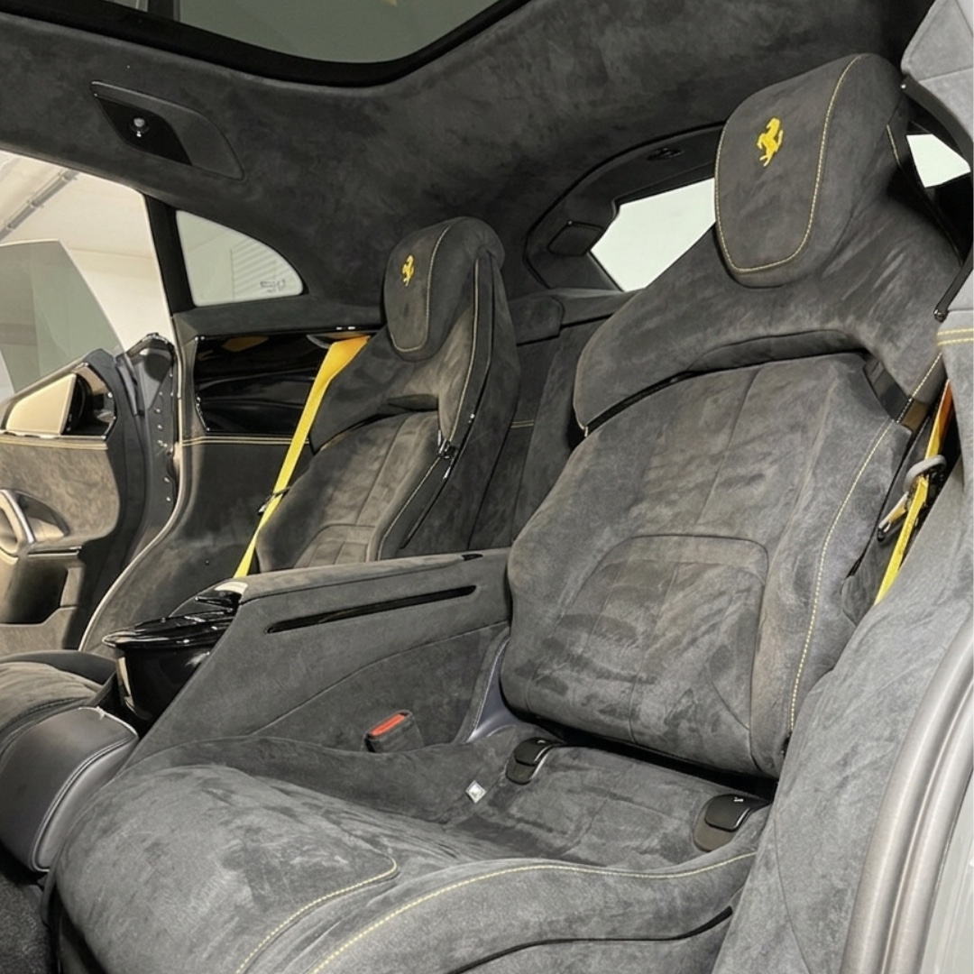 Graue Alcantara-Sitze mit gelben Details im Innenraum eines Ferrari